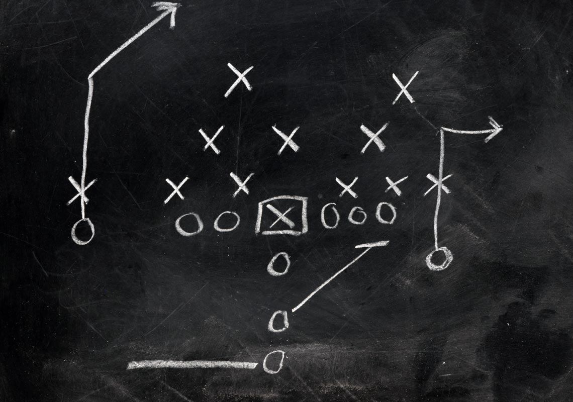 Football X's and O's on black chalkboard
